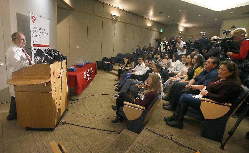 FILE - In this Dec. 8, 2016, file photo, Pediatric surgeon Gary Hartman, left, speaks to the media about the surgery on conjoined twins Eva and Erika Sandoval at the Lucile Packard Children's Hospital in Palo Alto, Calif. Formerly conjoined twins Eva and Erika Sandoval have left Lucile Packard Children's Hospital Stanford Thursday, March 8, 2017, and will be headed home in a few weeks. The 2 1/2-year-old Sacramento area girls, who were born conjoined from the chest down, were separated at the hospital. Dr. Hartman, who led the 50-person team that separated the twins in a 17-hour operation on Dec. 6, says the twins are doing great and have blossomed in their individual personalities. Before surgery, the girls shared a bladder, liver, parts of their digestive system and a third leg. Their parents say each girl retains portions of the organs they shared. Each still has one leg. (AP Photo/Tony Avelar, File)