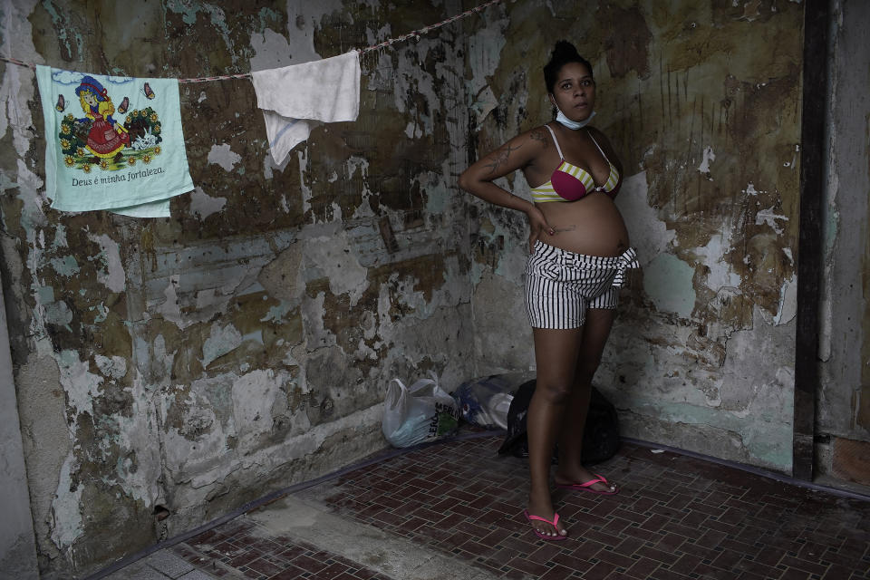 Actress Kelly Regina da Silva, who before the pandemic hit had made it out of her working-class slum, poses for a photo in the building where she now lives in a small room in one of the city center’s squats, in Rio de Janeiro, Brazil, Tuesday, March 16, 2021. Even among the world's richest nations, a PricewaterhouseCoopers survey this month found COVID-19 threatened to reverse the important gains women made over the last decade with “lasting, or even permanent” damage. (AP Photo/Silvia Izquierdo)