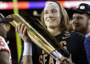 FILE - In this Jan. 7, 2019, file photo, Clemson's Trevor Lawrence holds the trophy after the NCAA college football playoff championship game against Alabama in Santa Clara, Calif. The 13-member College Football Playoff selection committee gathered at a resort hotel in Grapevine, Texas, Sunday, Nov. 3, 2019, to hammer out its first top 25 of the season. It will be revealed Tuesday night. (AP Photo/David J. Phillip, File)