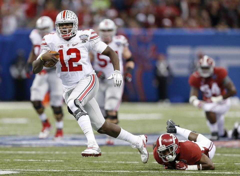 Ohio State Buckeyes quarterback Cardale Jones (12) gets away from Alabama Crimson Tide defensive back Nick Perry (27) during the second quarter in the Allstate Sugar Bowl college football playoff semifinal at Mercedes-Benz Superdome in New Orleans on Thursday, January 1, 2015. (Columbus Dispatch photo by Jonathan Quilter)