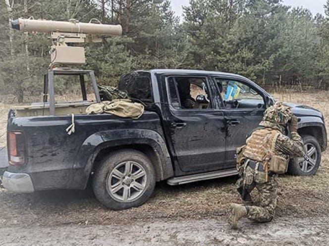 Ukrainian soldiers with a truck retrofitted by Cars4Ukraine