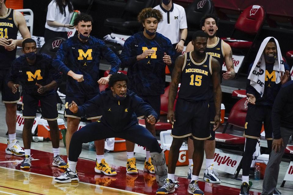 The Michigan bench react during the second half of an NCAA college basketball game against Wisconsin Sunday, Feb. 14, 2021, in Madison, Wis. (AP Photo/Morry Gash)