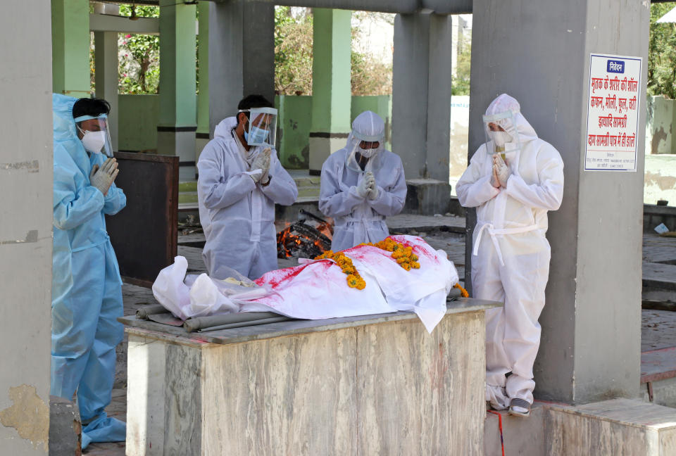 BEAWAR, RAJASTHAN, INDIA - 2021/04/23: (EDITORS NOTE: Image depicts death) Family members wearing protective suits, perform the last rites of a family memeber who died of COVID-19 at Hindu Moksha Dham crematorium in Beawar. (Photo by Sumit Saraswat/Pacific Press/LightRocket via Getty Images)