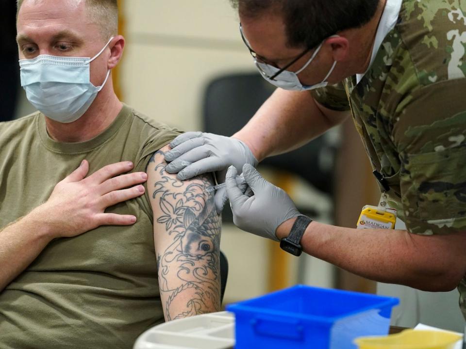 Staff Sgt. Travis Snyder receives the first dose of the Pfizer vaccine at Madigan Army Medical Center at Joint Base Lewis-McChord in Washington state on Dec. 16, 2020.