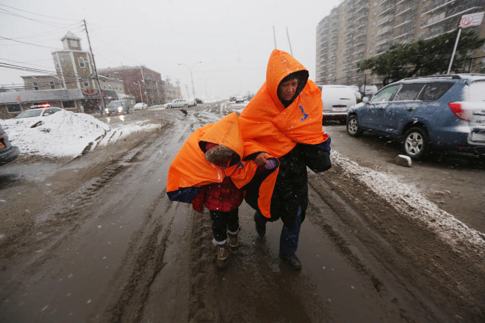 Fatima Quentiro walks with her granddaughter Galalea Castro through the snow to a bus stop to take a bus to Quenitro?s home after Castro?s home was damaged by flooding as a Nor?Easter approaches in the Rockaway neighborhood on November 7, 2012 in the Queens borough of New York City. The two are wearing jackets donated by the NYC Marathon. The Rockaway Peninsula was especially hard hit by Superstorm Sandy and some are evacuating ahead of the coming storm. (Photo by Mario Tama/Getty Images)