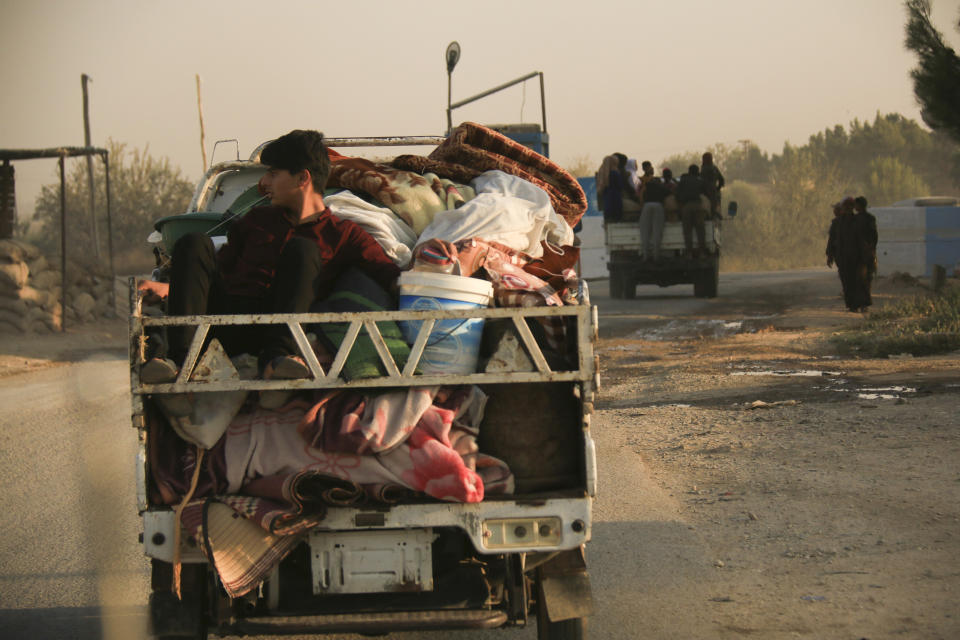 Syrians flee shelling by Turkish forces in Ras al Ayn, northeast Syria, Wednesday, Oct. 9, 2019. Turkish President Recep Tayyip Erdogan announced Wednesday the start of a Turkish military operation against Kurdish fighters in northeastern Syria. (AP Photo/Baderkhan Ahmad)