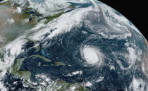 This GOES-16 GeoColor satellite image taken Friday, Sept. 18, 2020, at 12:20 p.m. EDT., and provided by NOAA, shows Hurricane Teddy, center, in the Atlantic, Tropical Depression 22, left, in the Gulf of Mexico, the remnants Paulette, top right, and Tropical Storm Wilfred, lower right. Forecasters have run out of traditional names for the Atlantic hurricane season. Tropical Storm Wilfred, the last of traditional names, officially formed little more than an hour before subtropical storm Alpha, prompting the hurricane center to tweet “get out the Greek alphabet.” (NOAA via AP)