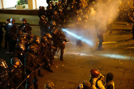 A police officer sprays the crowd with an irritant during a protest against the election of Republican Donald Trump as President of the United States in Portland, Oregon, U.S. November 12, 2016. REUTERS/William Gagan