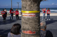 A group of women stand along the beach, commemorating International Women's Day by calling for the release of hostages held by Hamas in the Gaza Strip in Tel Aviv, Israel, March 8, 2024. Some 130 hostages remain in Gaza as the Israel-Hamas war enters its sixth month, and Israel's government says 19 of them are women. (AP Photo/Oded Balilty)