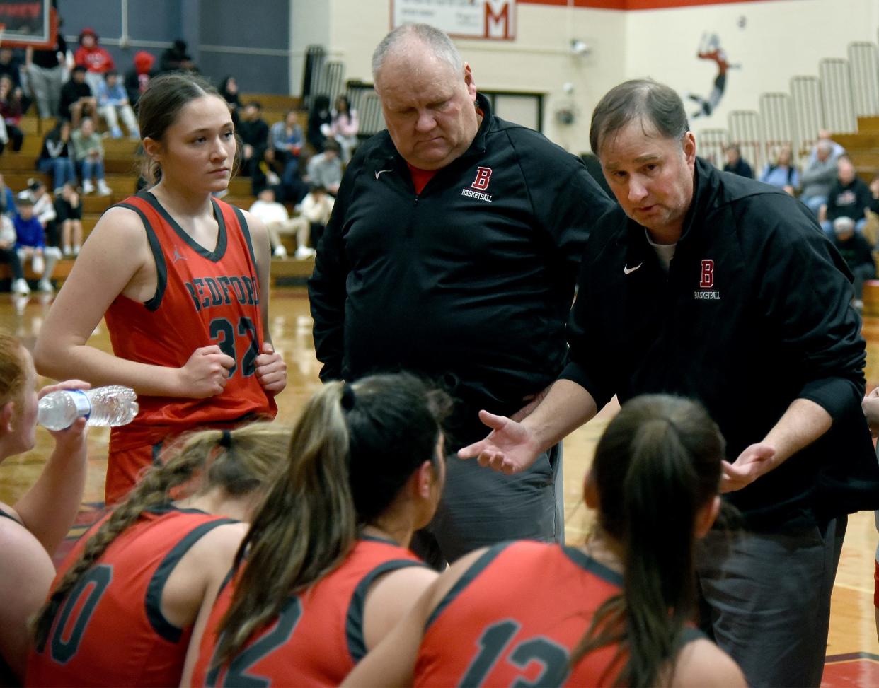 Bill Cappi (right) and Les Manley, interim coaches for Bedford's girls basketball team, talk to their team during a victory over Monroe Friday night.