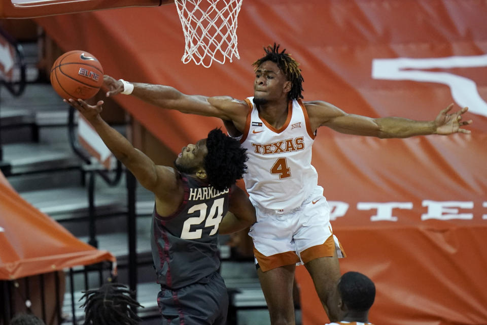 Oklahoma guard Elijah Harkless (24) is blocked by Texas forward Greg Brown (4) during the first half of an NCAA college basketball game Tuesday, Jan. 26, 2021, in Austin, Texas. (AP Photo/Eric Gay)