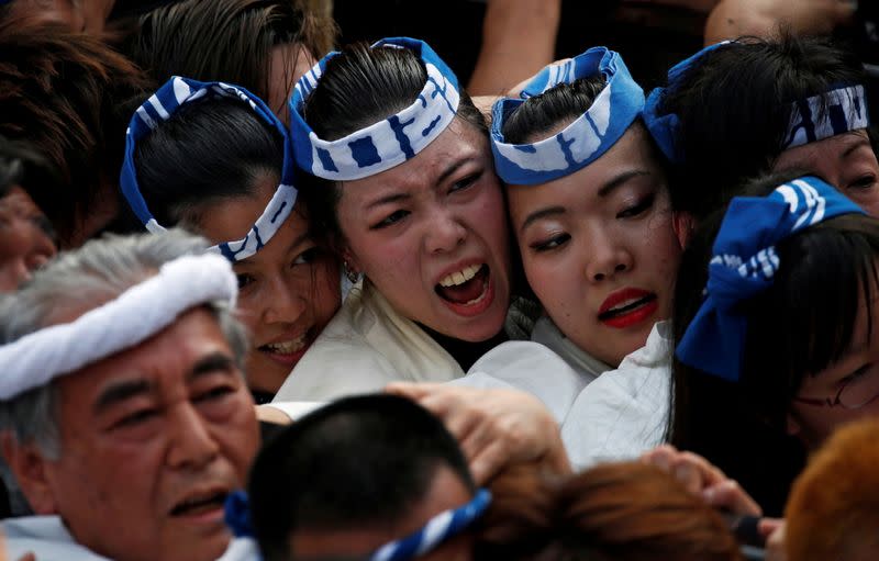 FILE PHOTO: Shrine parishioners carry a portable shrine into the Kanda Myojin Shrine during the Kanda festival, one of the three major Shinto festivals in Tokyo