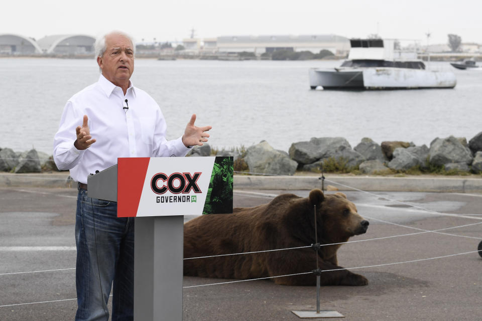 In this May 11, 2021, file photo California gubernatorial candidate John Cox speaks in front of his Kodiak bear at a campaign event held on Shelter Island in San Diego. Cox was the Republican nominee for governor in 2018 and lost to Newsom in a landslide. This time around the multimillionaire businessman has displayed a showman’s instincts. (AP Photo/Denis Poroy, File)