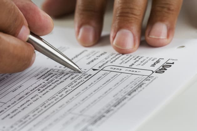 Close up of hands filling in tax form