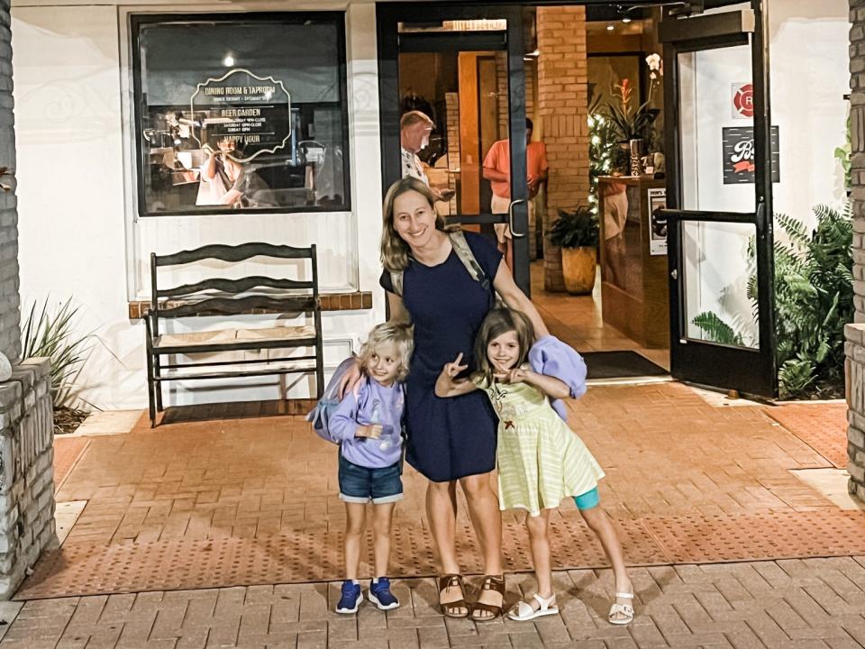 a woman with two children in front of a restaurant orlando florida