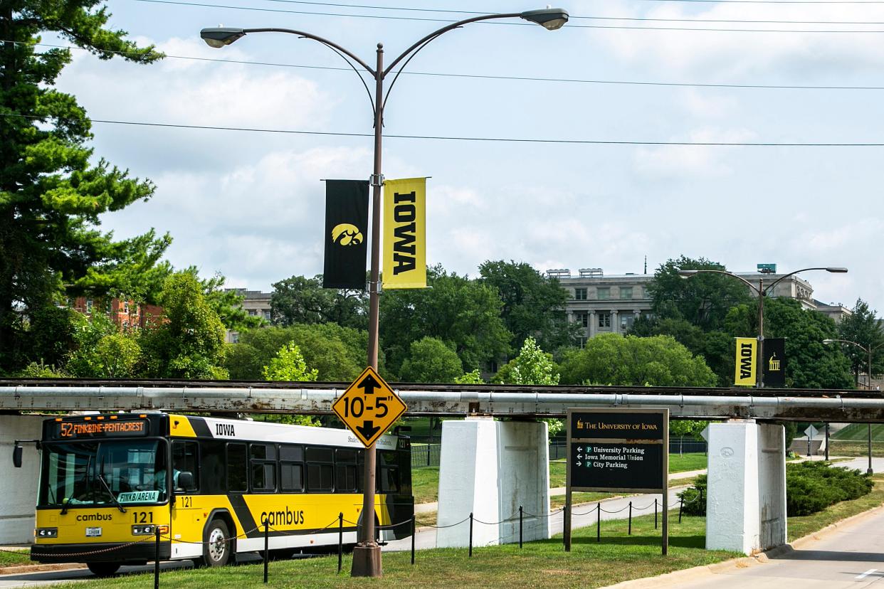 A Cambus bus drives below the CRANDIC rail line bridge on Iowa Avenue, Monday, Aug. 9, 2021, in Iowa City, Iowa.