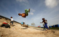 <p>Youths somersault over old tires in the Khayelitsha township, near Cape Town, South Africa May 25, 2017. (Photo: Mike Hutchings/Reuters) </p>