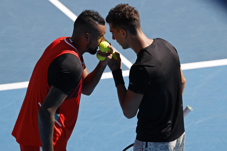 Nick Kyrgios, left, and partner Thanasi Kokkinakis of Australia talk during their doubles match against Germany's Tim Puetz and Michael Venus of New Zealand at the Australian Open tennis championships in Melbourne, Australia, Tuesday, Jan. 25, 2022. (AP Photo/Tertius Pickard)