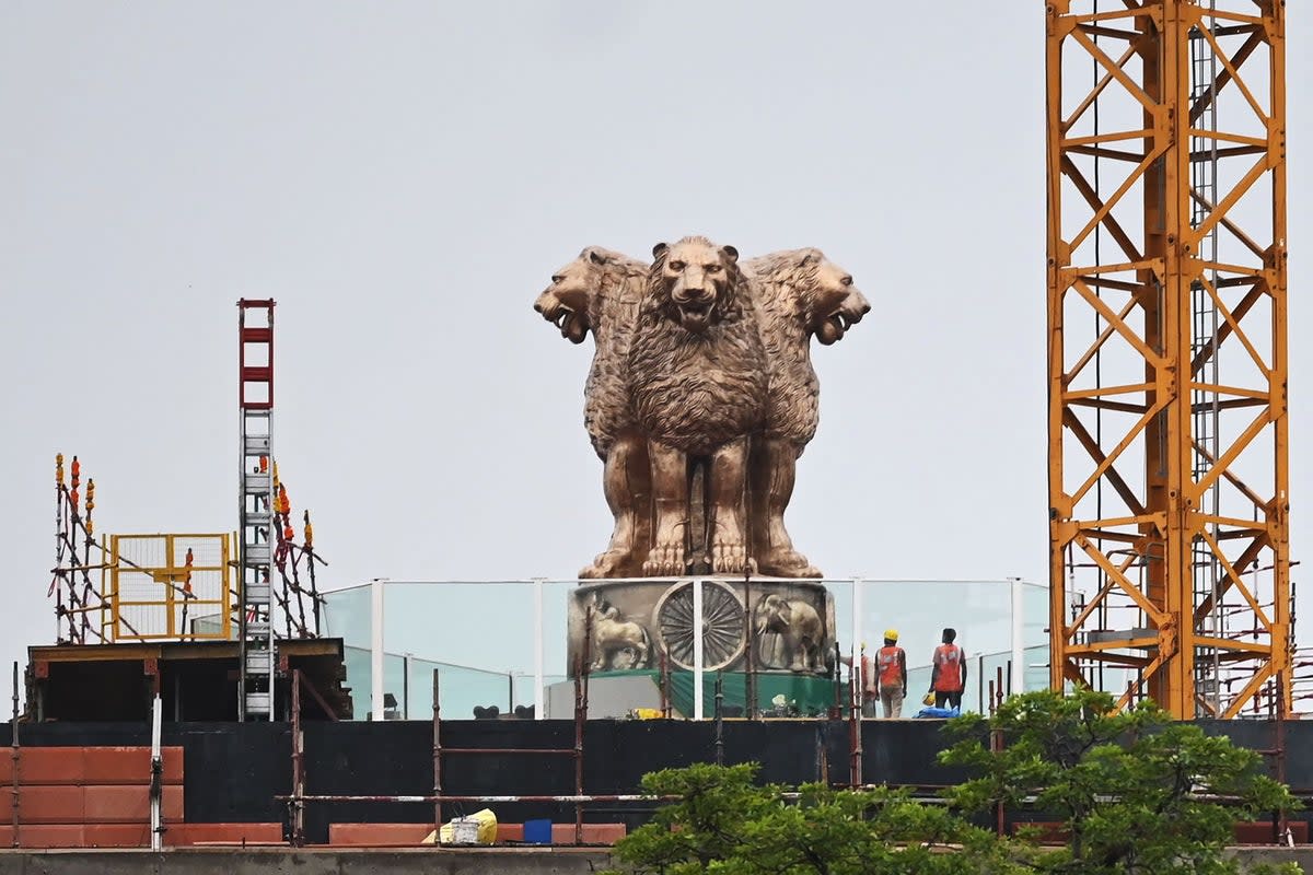  File: Workers stand next to the newly inaugurated ‘National Emblem’ installed on the roof of the new Indian parliament building in New Delhi (AFP via Getty Images)