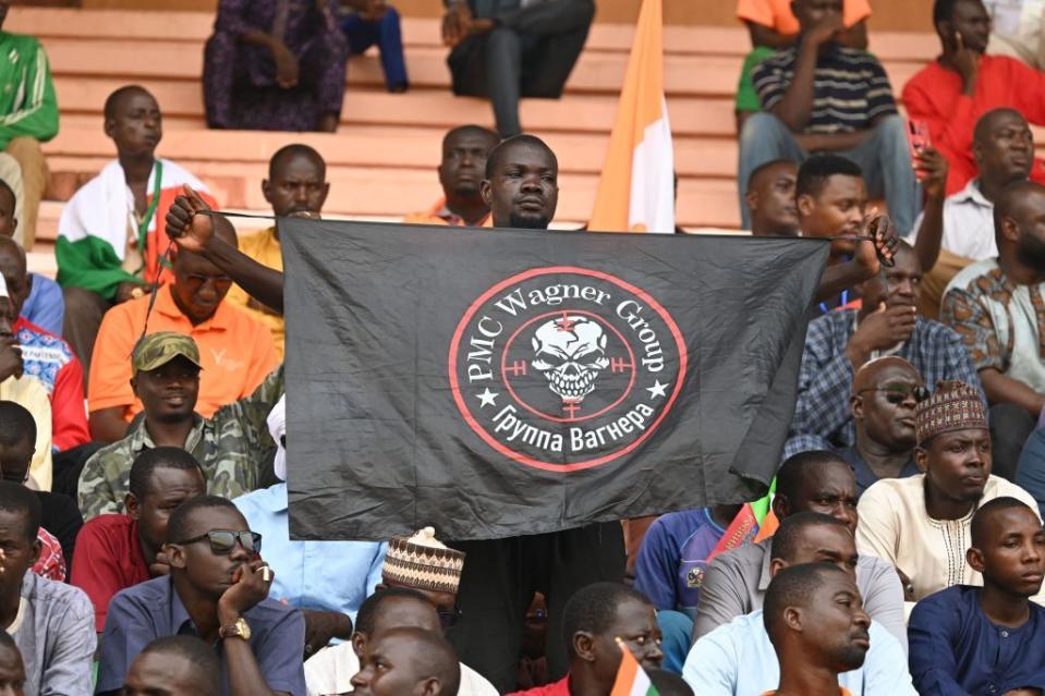 A man holds a flag bearing the logo of Private Military Company Wagner as supporters of Niger's National Council for Safeguard of the Homeland (CNSP) gather at the general Seyni Kountche stadium in Niamey on Aug. 26, 2023. Tens of thousands of people rallied in Niamey on Aug. 26, 2023 in support for the military leaders behind last month's coup, a day after an ultimatum was issued to France's ambassador to Niger to leave the country. (Photo by AFP via Getty Images)