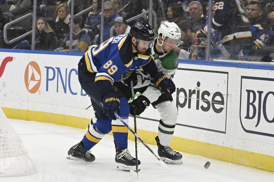 Dallas Stars defenseman Thomas Harley (55) and St. Louis Blues left wing Pavel Buchnevich (89) fights for the puck during the second period of an NHL hockey game Wednesday, Dec. 27, 2023, in St. Louis. (AP Photo/Michael Thomas)