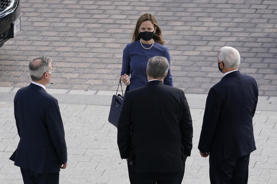 Supreme Court nominee Judge Amy Coney Barrett, center, walks towards White House Counsel Pat Cipollone, left, White House Chief of Staff Mark Meadows, center, and Vice President Mike Pence, right as they arrive on Capitol Hill in Washington, Tuesday, Sept. 29, 2020. (AP Photo/Susan Walsh, POOL)