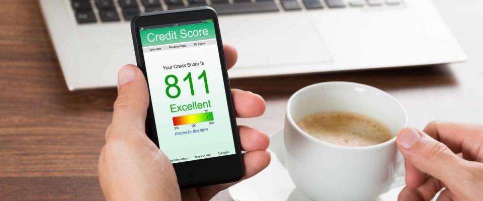 Close-up Of A Businessman Checking Credit Score Online On Cellphone While Having Coffee