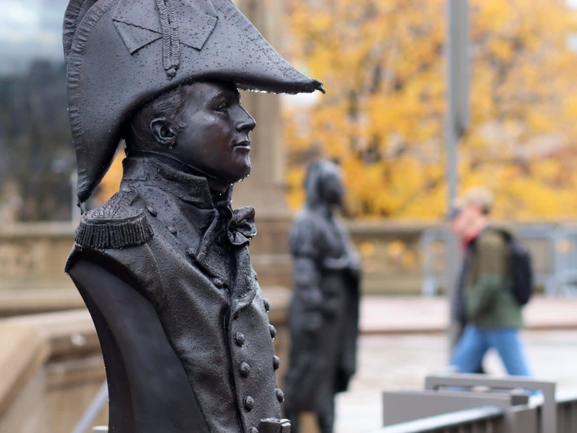 People walk past statues on a rainy day in downtown Ottawa on Nov. 12, 2021. (Trevor Pritchard/CBC - image credit)