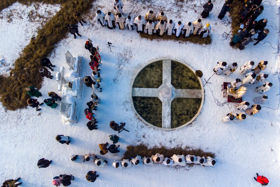 January 18, 2022 :  Orthodox priests conduct a religion service blessing the ice water of the Tura river during a traditional Epiphany celebration as the temperature is about 23 degrees Fahrenheit at the Holy Trinity Monastery in Tyumen, Russia.