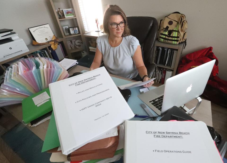 Former New Smyrna Beach Fire Department Lt. Melissa Smith in her home office, Wednesday April 17, 2024 surrounded by stacks of paperwork from her discrimination lawsuit.