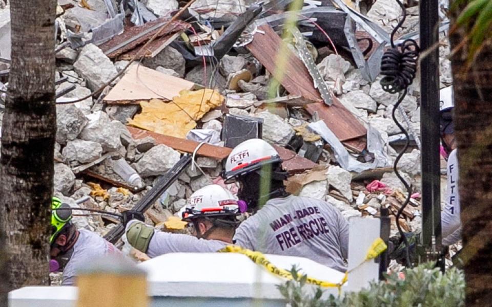 Miami-Dade County Fire Rescue members search at the site of the Champlain Towers South Condo - Miami Herald