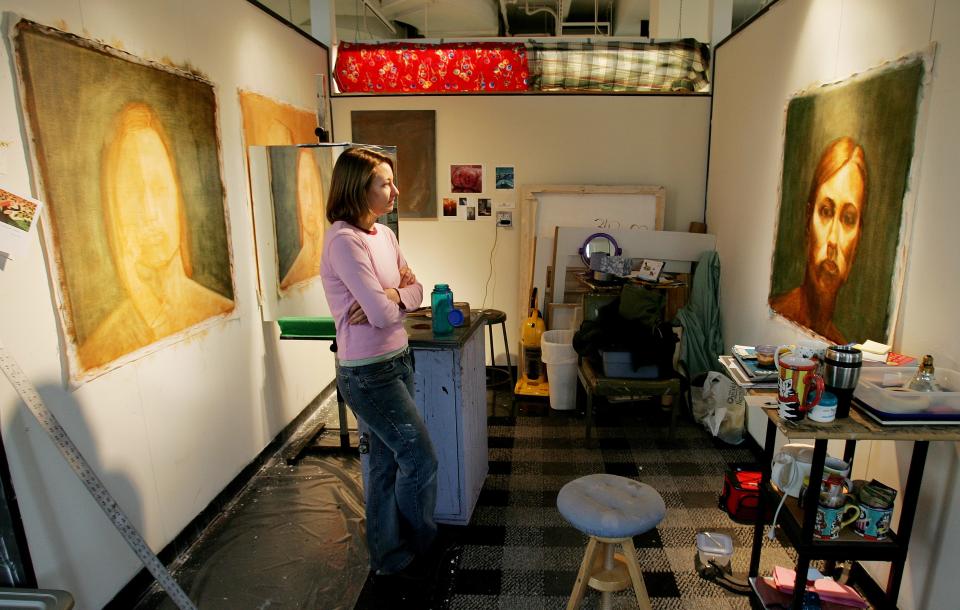 Surrounded by self-portraits in progress, Kelley Crowley, an Art 5 student at UMass Dartmouth's Star Store campus, takes some time to just look at her work, herself.