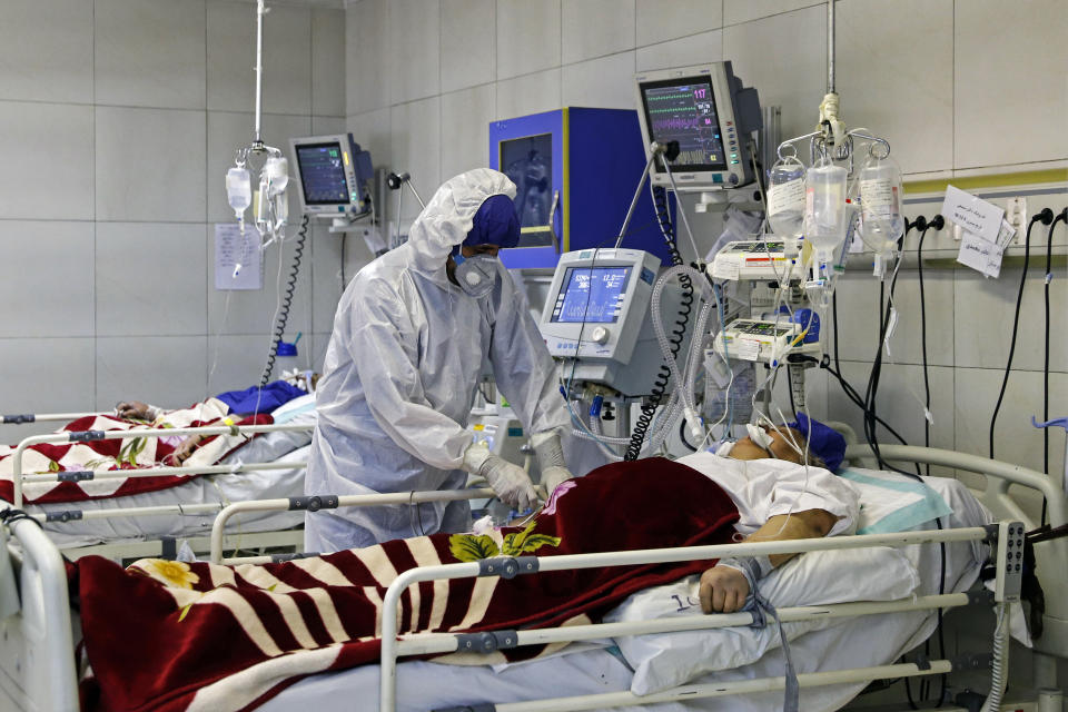 FILE — In this March 1, 2020 file photo, a medic treats a patient infected with coronavirus, at a hospital in Tehran, Iran. Dozens of medical staffers have died of COVID-19 in Iran. Doctors and nurses and other staffers have been hard hit. During the first 90 days of the virus outbreak alone, about one medical staffer died each day. (Ali Shirband/Mizan News Agency via AP, File)