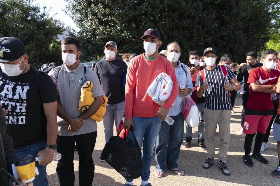 FILE - Migrants hold Red Cross blankets after arriving at Union Station near the U.S. Capitol from Texas on buses on April 27, 2022, in Washington. Two Republican border-state governors who are investing billions of dollars on immigration enforcement and hours at the podium blasting the Biden administration policies have found two unlikely allies: Democratic mayors Muriel Bowser of Washington, D.C., and Eric Adams of New York. The mayors' recent overtures for federal aid is a response to Texas and Arizona busing migrants away from the border, a months-old practice that has been long on political theater and short on practical impact. (AP Photo/Jose Luis Magana, File)