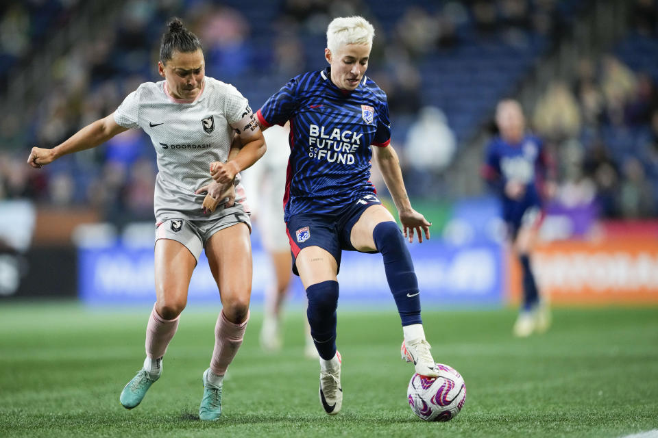 OL Reign forward Megan Rapinoe, right, moves the ball against Angel City FC defender Ali Riley, left, during the first half of an NWSL quarterfinal playoff soccer match Friday, Oct. 20, 2023, in Seattle. (AP Photo/Lindsey Wasson)