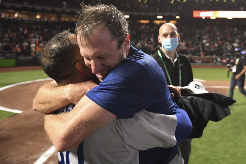 San Francisco, CA - October 14: Los Angeles Dodgers' Max Scherzer, right, hugs manager Dave Roberts after game five of the 2021 National League Division Series against the San Francisco Giants at Oracle Park on Thursday, Oct. 14, 2021 in San Francisco, CA. The Dodgers won 2-1. (Wally Skalij / Los Angeles Times)