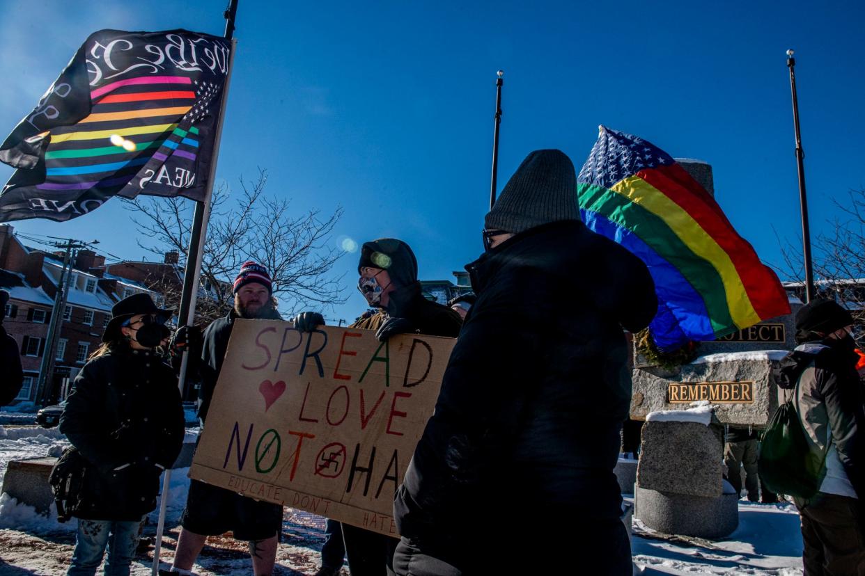 York, Maine resident Shane Bell, 47, center, holds a sign in support of the "Honey Punch & Pals" drag queen story hour show and its performers at the Seacoast Repertory Theatre during a demonstration outside the Portsmouth theater Saturday, Jan. 8, 2022.