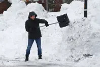 A person clears snow after a winter storm rolled through Western New York Tuesday, Dec. 27, 2022, in Amherst, N.Y. (AP Photo/Jeffrey T. Barnes)