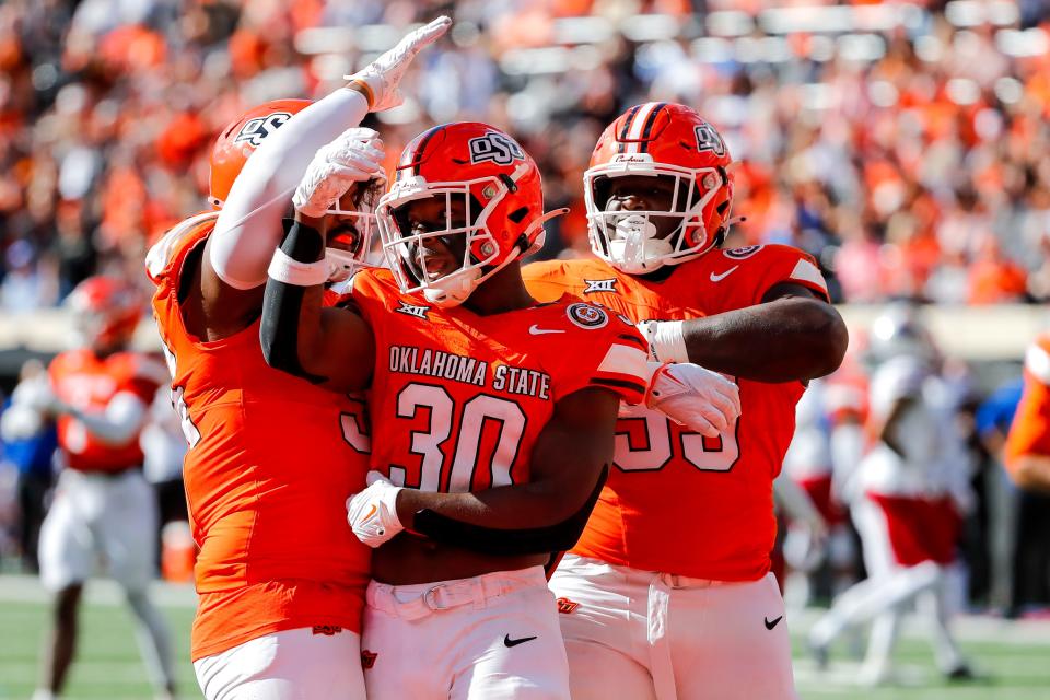 Oct 14, 2023; Stillwater, Oklahoma, USA; Oklahoma State's Collin Oliver (30) celebrates after sacking Kansas’s Jason Bean (9) in the second quarter during an NCAA football game between Oklahoma State (OSU) and Kansas at Boone Pickens Stadium. Mandatory Credit: Nathan J. Fish-USA TODAY Sports