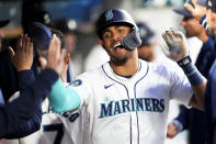 Seattle Mariners' Julio Rodríguez celebrates in the dugout after scoring on a bases-loaded walk during the fifth inning of the team's baseball game against the Cincinnati Reds on Tuesday, April 16, 2024, in Seattle. (AP Photo/Lindsey Wasson)