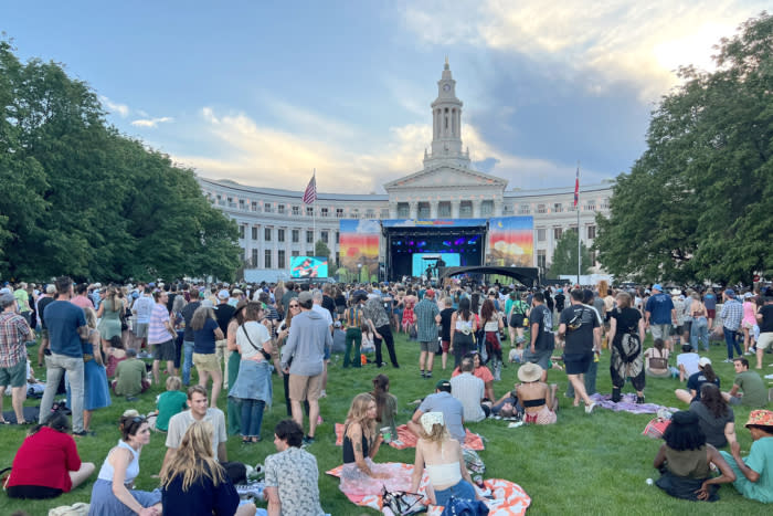 People relax on the lawn at Civic Center Park in Denver during a musical performance at the Outside Festival; (photo/Sean McCoy)