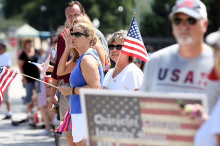 Spectators watch a hearse containing the body of the late Senator John McCain arrive for a private memorial service and burial at the U.S. Naval Academy in Annapolis, U.S., September 2, 2018. REUTERS/Mary F. Calvert