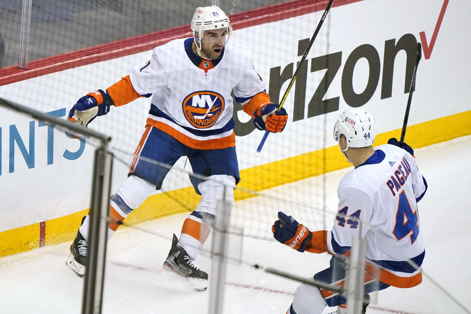 New York Islanders' Kyle Palmieri (21) celebrates with Jean-Gabriel Pageau (44) after scoring during the first period in Game 1 of an NHL hockey Stanley Cup first-round playoff series against the Pittsburgh Penguins in Pittsburgh, Sunday, May 16, 2021. (AP Photo/Gene J. Puskar)