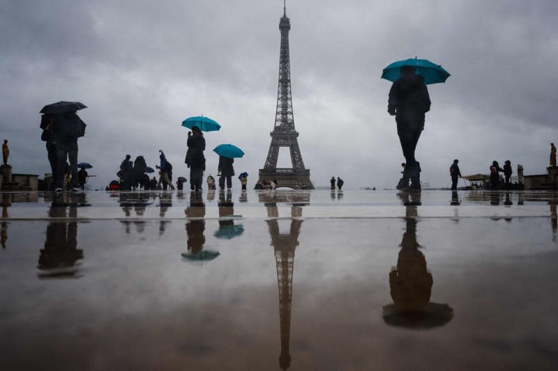 Visitors walk at the Esplanade du Trocadero with the Eiffel Tower in the background, which is closed to the public on the fourth day of its staff's strike. Dimitar Dilkoff/AFP/dpa