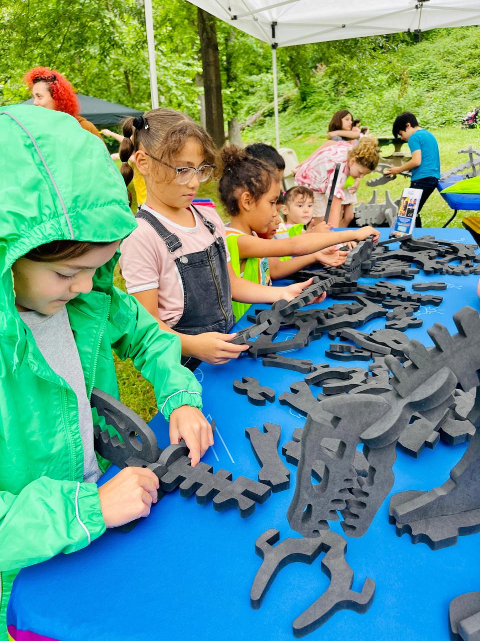 Children build foam dinosaurs at the Muse tent at Kid A’Riffic Fun in the Park at Fountain City Park on June 7, 2023.