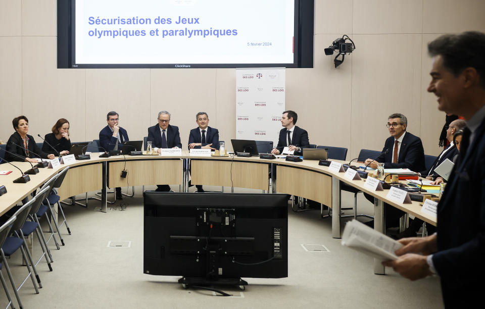 French Interior Minister Gerald Darmanin sits between lawmakers as he attends an Olympics security hearing at the Senate in Paris, Tuesday, March 5, 2024. The French government announced that tourists won't be allowed to watch the opening ceremony of the Paris Olympics for free as initially promised, the government announced Tuesday, as it grapples with security concerns about the unprecedented open-air event along the Seine River. Screen reads, Olympic and Paralympic security. (AP Photo/Thomas Padilla)