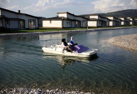 Tourists from the Middle East ride a boat through Sarajevo Resort in Osenik near Sarajevo, Bosnia and Herzegovina, August 10, 2016. Picture taken August 10, 2016. REUTERS/Dado Ruvic