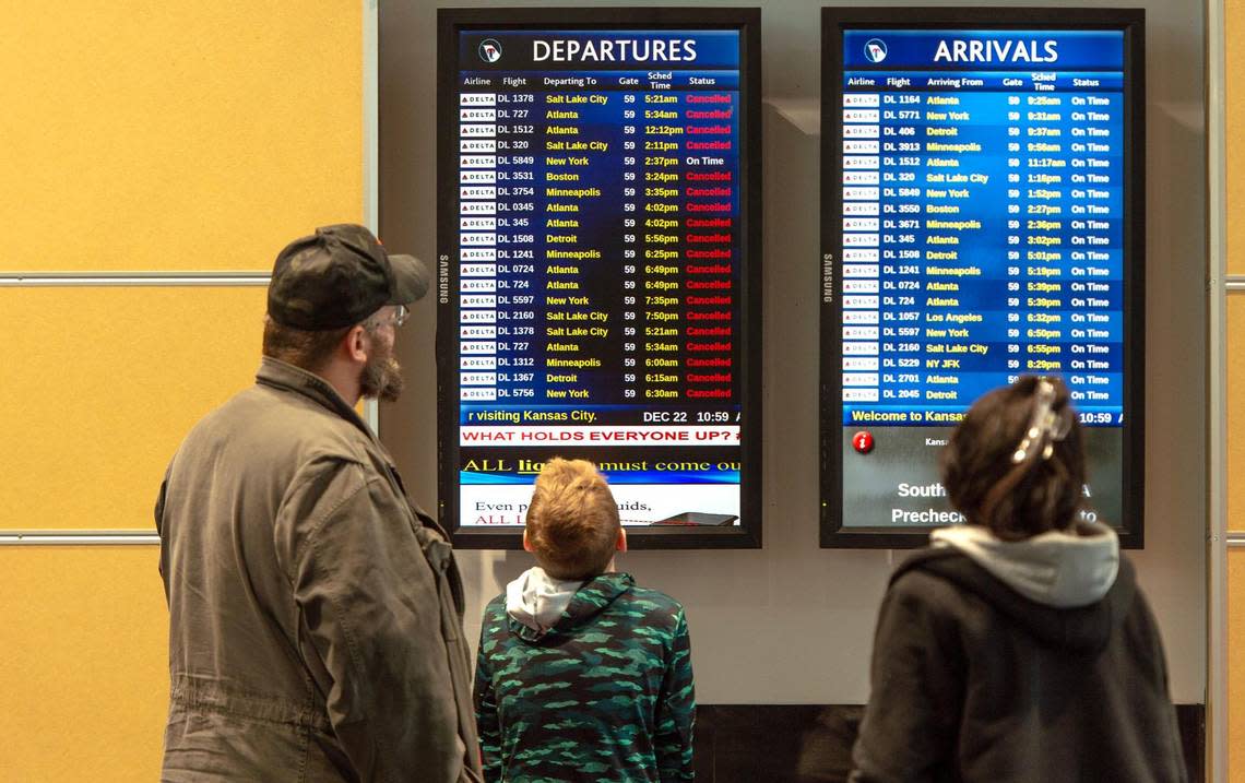 People look at a list of canceled flights at Kansas City International Airport on Thursday, Dec. 22, 2022, in Kansas City.