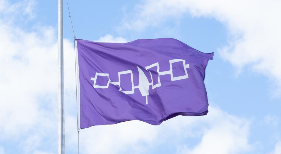 The Haudenosaunee flag waving in the wind on Syracuse University Campus
