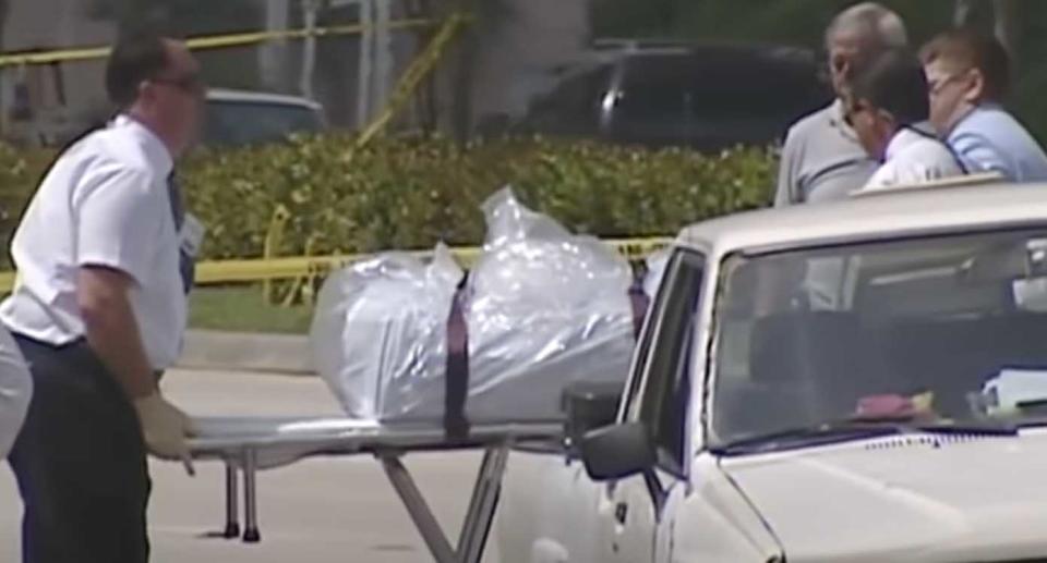 Police remove a body found roadside in Broward County in June 2000.